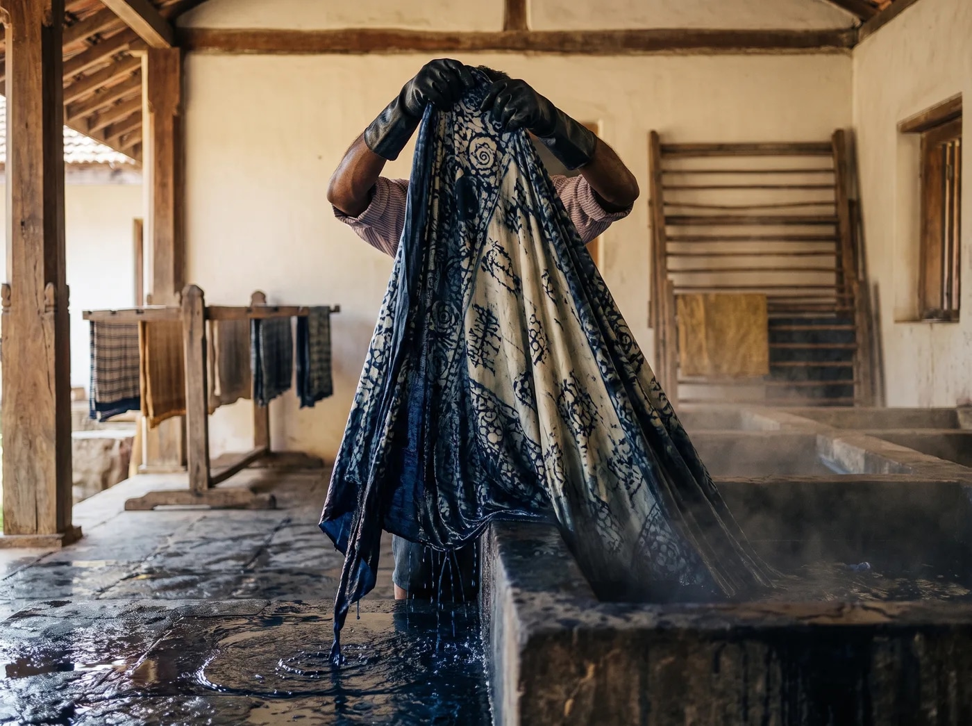 Indigo-dyed cotton being lifted from a dye vat.